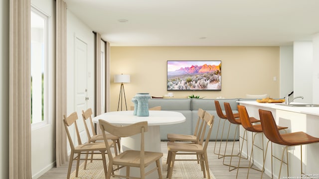 dining area with light wood-type flooring and sink