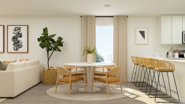 dining space with light hardwood / wood-style flooring and sink