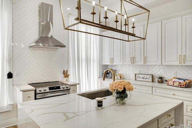 kitchen featuring white cabinetry, electric range, sink, wall chimney exhaust hood, and light stone counters