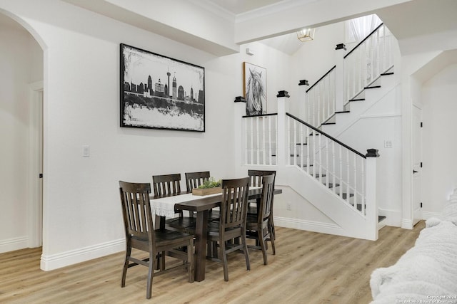 dining space with a chandelier, light wood-type flooring, and crown molding