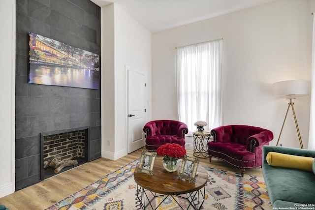 living room featuring hardwood / wood-style flooring and a tiled fireplace