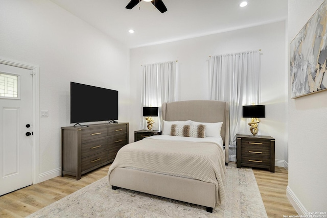 bedroom with ceiling fan, light hardwood / wood-style flooring, and lofted ceiling