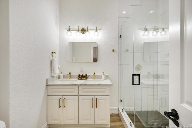 bathroom featuring hardwood / wood-style floors, vanity, and a shower with door