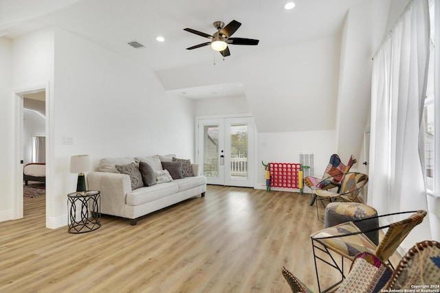 living room featuring ceiling fan, vaulted ceiling, light hardwood / wood-style floors, and french doors