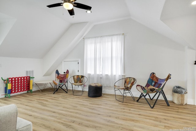 living area with vaulted ceiling, light hardwood / wood-style flooring, and ceiling fan