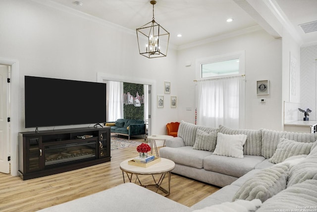 living room with light hardwood / wood-style flooring, a chandelier, and ornamental molding