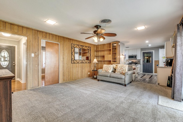 living room with light colored carpet, ceiling fan, and ornamental molding