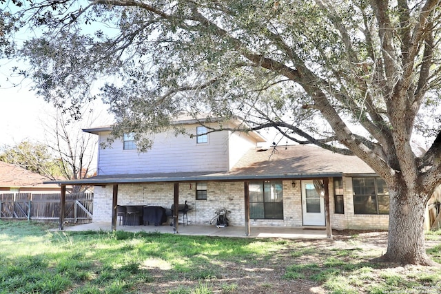 back of house with a patio area and a lawn