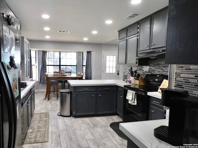 kitchen with black electric range, light wood-type flooring, kitchen peninsula, and fridge with ice dispenser