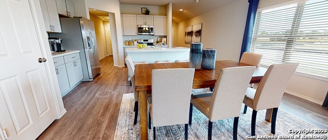 dining room with light hardwood / wood-style floors and vaulted ceiling