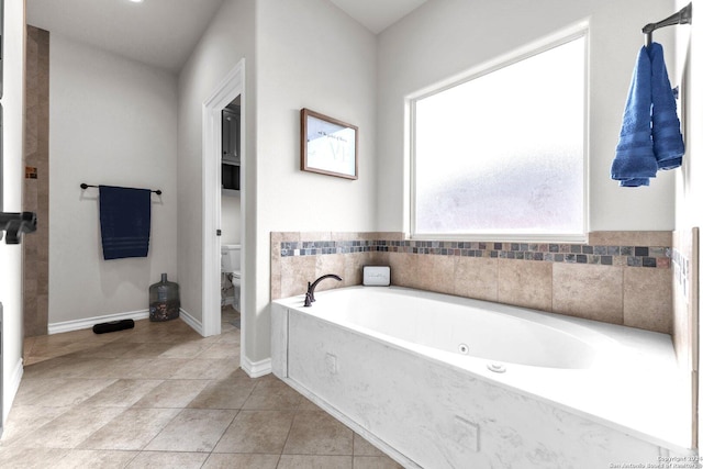 bathroom with tile patterned floors, a bathtub, and toilet