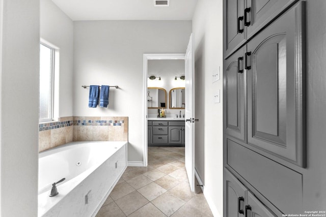 bathroom featuring tile patterned flooring, vanity, and a tub