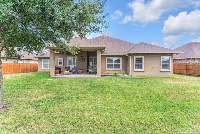 back of house with a lawn and a patio