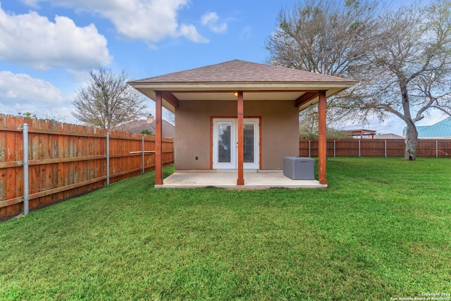 back of house with a lawn, a patio area, and central AC