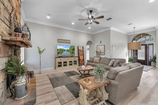 living room with light hardwood / wood-style floors, ornamental molding, and a wealth of natural light