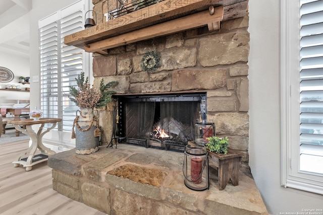 room details with hardwood / wood-style floors and a stone fireplace