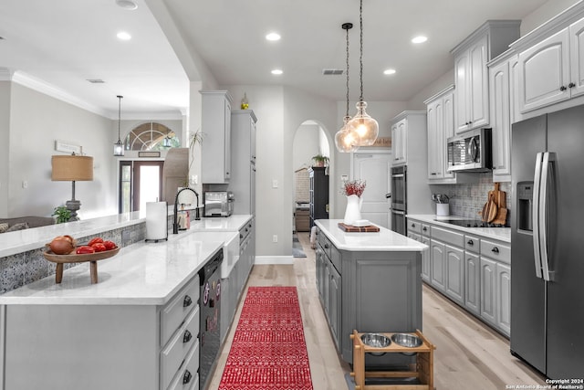 kitchen with a center island, decorative light fixtures, gray cabinets, decorative backsplash, and black appliances