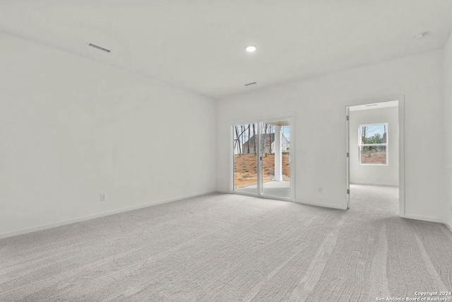 spare room with light colored carpet and a wealth of natural light