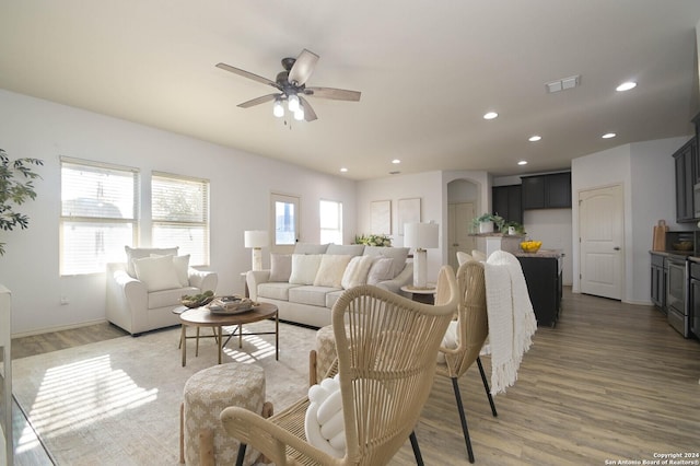 living room featuring wood-type flooring and ceiling fan