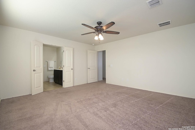 unfurnished bedroom featuring ensuite bath, ceiling fan, and light carpet