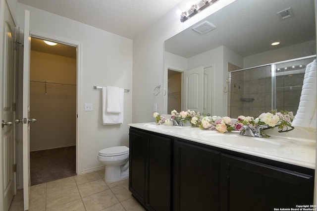 bathroom with tile patterned floors, toilet, vanity, and walk in shower