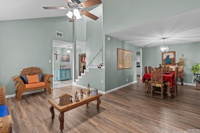 living room featuring hardwood / wood-style flooring, ceiling fan with notable chandelier, and high vaulted ceiling