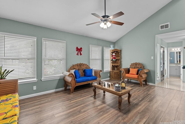 living room featuring vaulted ceiling, ceiling fan, and dark wood-type flooring