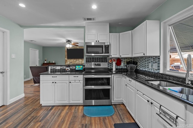 kitchen featuring sink, dark wood-type flooring, backsplash, white cabinets, and appliances with stainless steel finishes