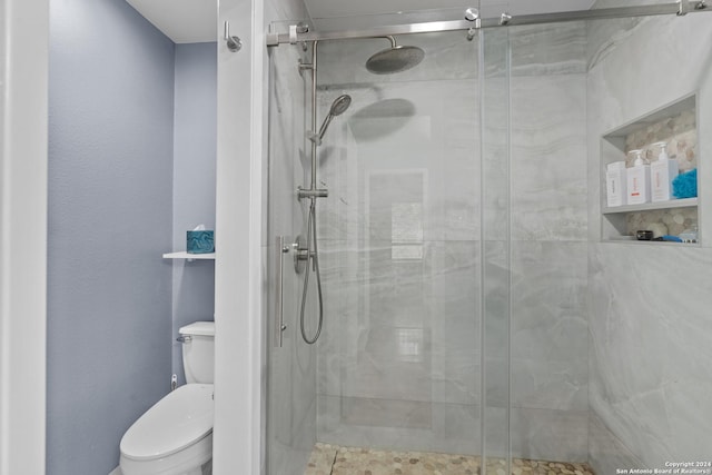 bathroom with an enclosed shower and toilet