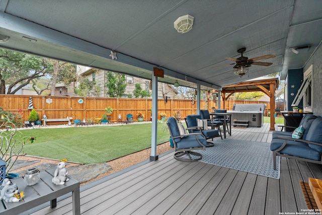 deck with ceiling fan, a grill, a yard, and a hot tub