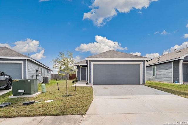 view of front of home featuring central air condition unit, a front lawn, and a garage