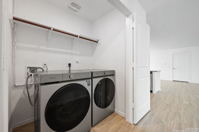 laundry room with separate washer and dryer and light wood-type flooring