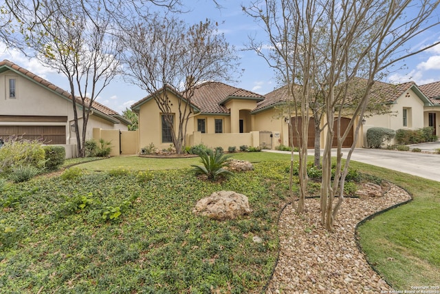 mediterranean / spanish house featuring a garage and a front yard