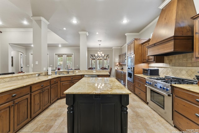 kitchen featuring a center island, stainless steel appliances, a notable chandelier, decorative backsplash, and custom range hood