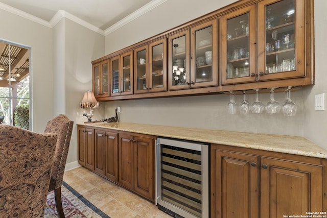 bar with light stone counters, crown molding, and beverage cooler