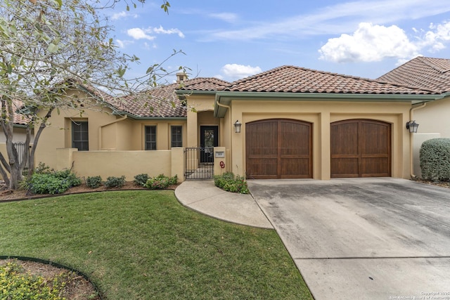 mediterranean / spanish home with a garage and a front lawn