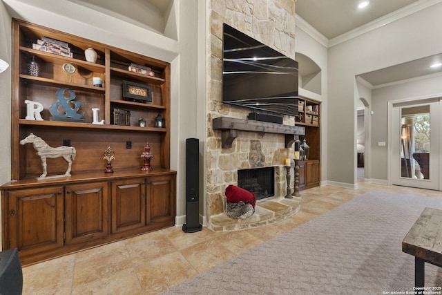 living room with built in shelves, a fireplace, and ornamental molding