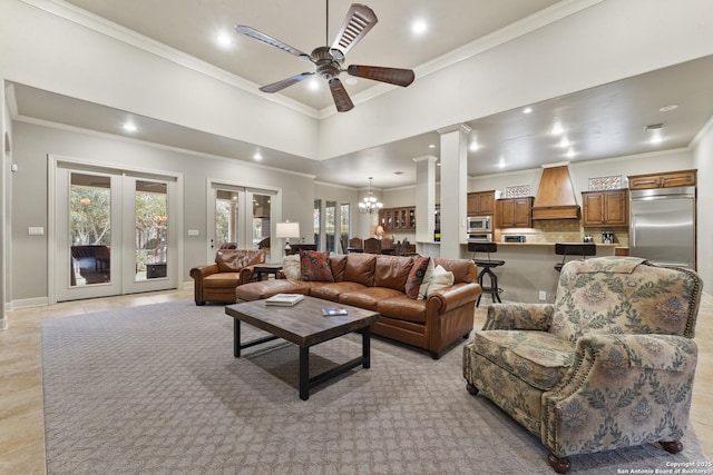 living room with light tile patterned floors, ceiling fan with notable chandelier, ornate columns, and a healthy amount of sunlight