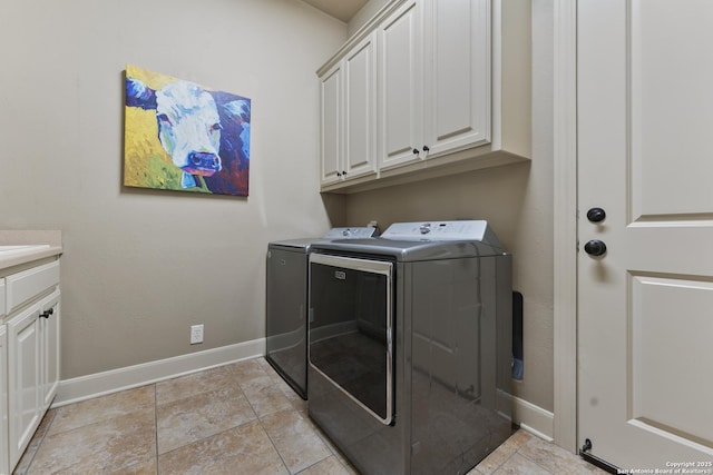 laundry room with washing machine and clothes dryer and cabinets