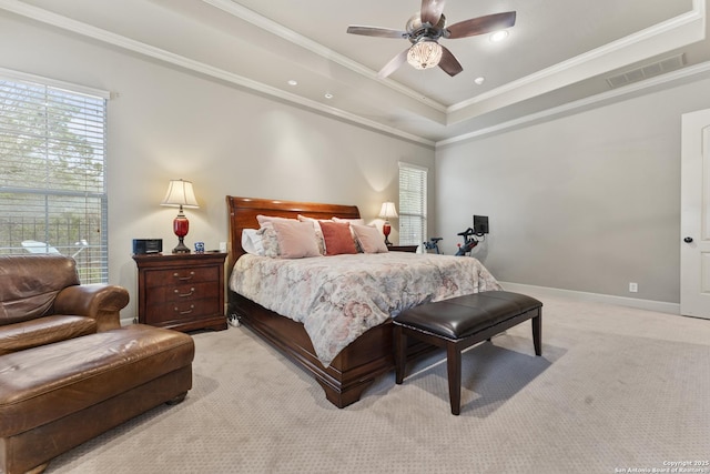 bedroom with a tray ceiling, crown molding, ceiling fan, and light colored carpet