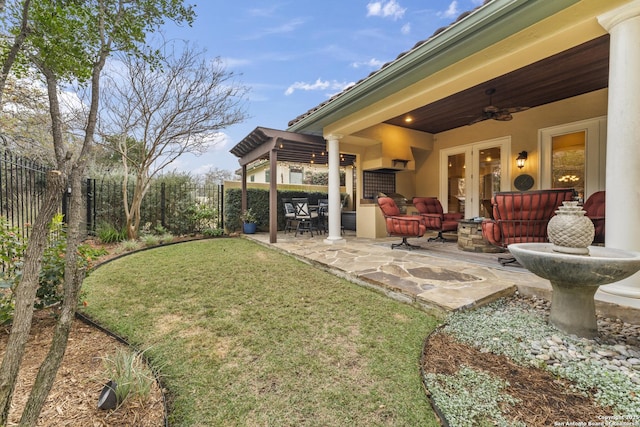 view of yard featuring a patio area, ceiling fan, and french doors