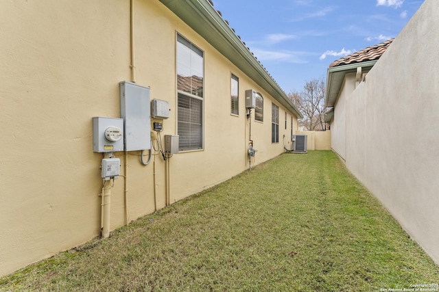 view of side of home featuring a yard and central air condition unit