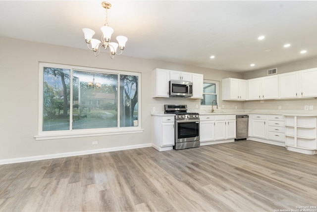 kitchen featuring a notable chandelier, white cabinets, light hardwood / wood-style flooring, appliances with stainless steel finishes, and decorative light fixtures