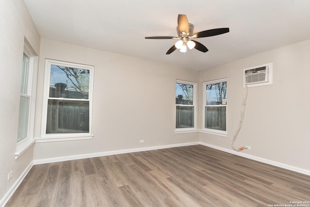 spare room featuring hardwood / wood-style flooring, ceiling fan, and a wall mounted air conditioner