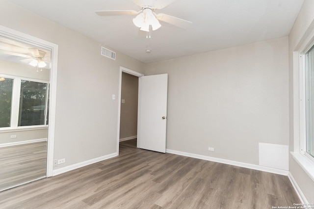 unfurnished bedroom featuring ceiling fan, a closet, and wood-type flooring