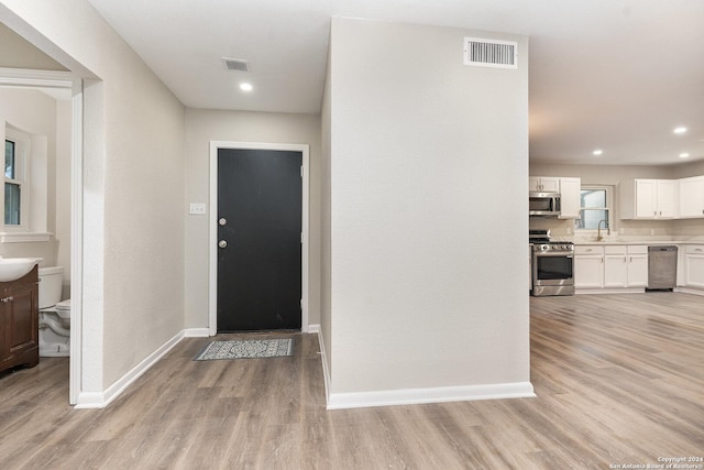 foyer featuring sink and light hardwood / wood-style floors