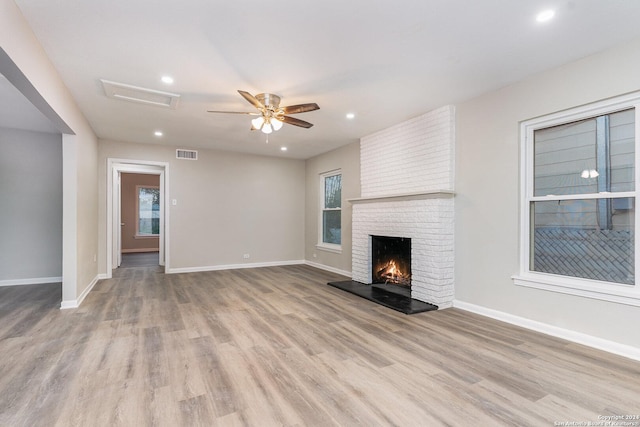 unfurnished living room with a fireplace, light hardwood / wood-style floors, and ceiling fan