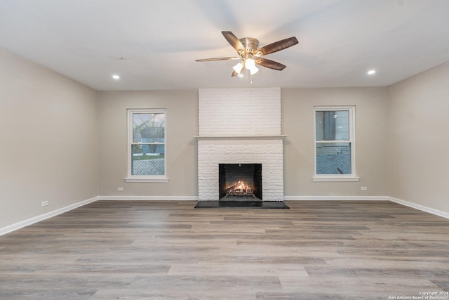 unfurnished living room with a fireplace, light hardwood / wood-style flooring, and ceiling fan