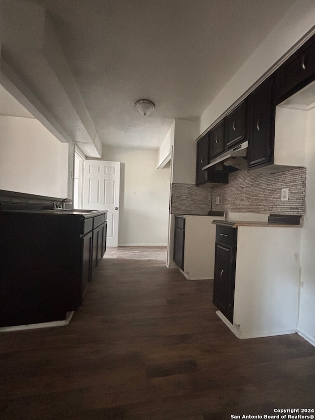 kitchen with tasteful backsplash, dark hardwood / wood-style flooring, and sink