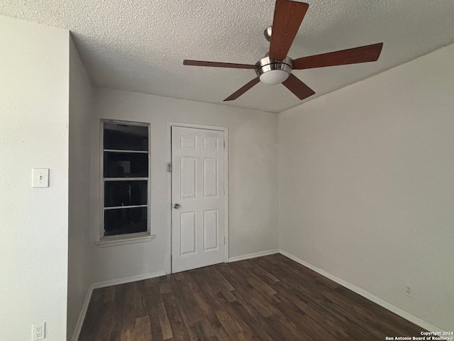 unfurnished room featuring ceiling fan, dark wood-type flooring, and a textured ceiling